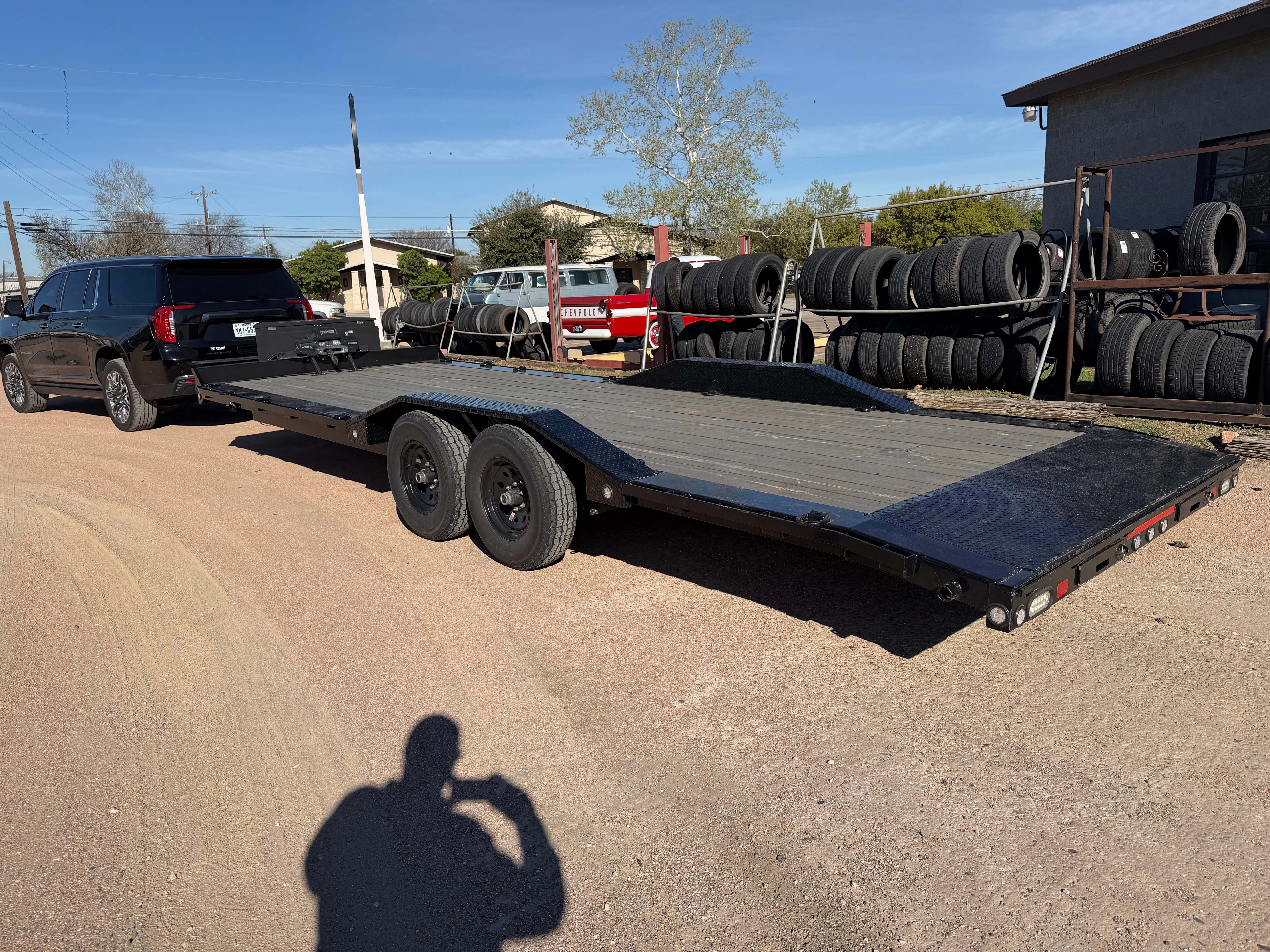Maxx-D H5X car hauler side profile hitched to black SUV